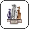 Three stylized cosmetic statues in purple, silver, and bronze on display stands labeled 'WINNER', '2ND PLACE', and '3RD PLACE'.